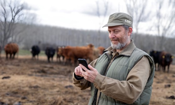 An image showing a farmer using his phone in a remote area