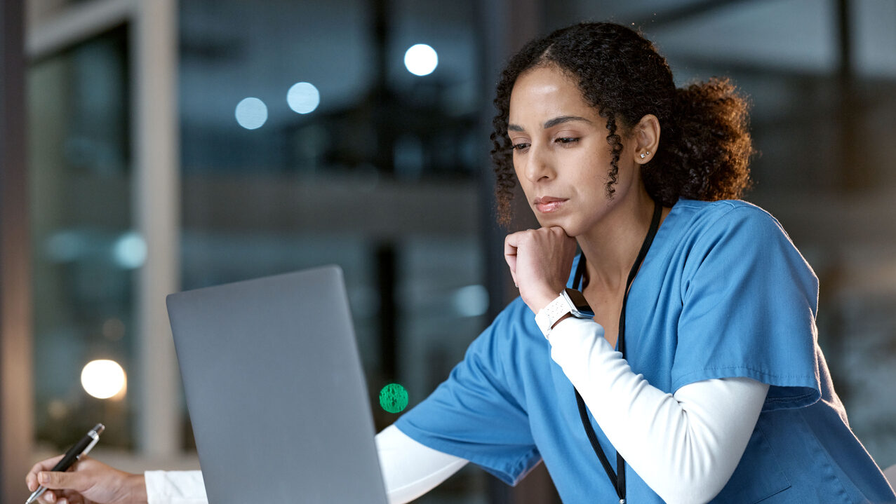 Doctor working alone at her laptop at night